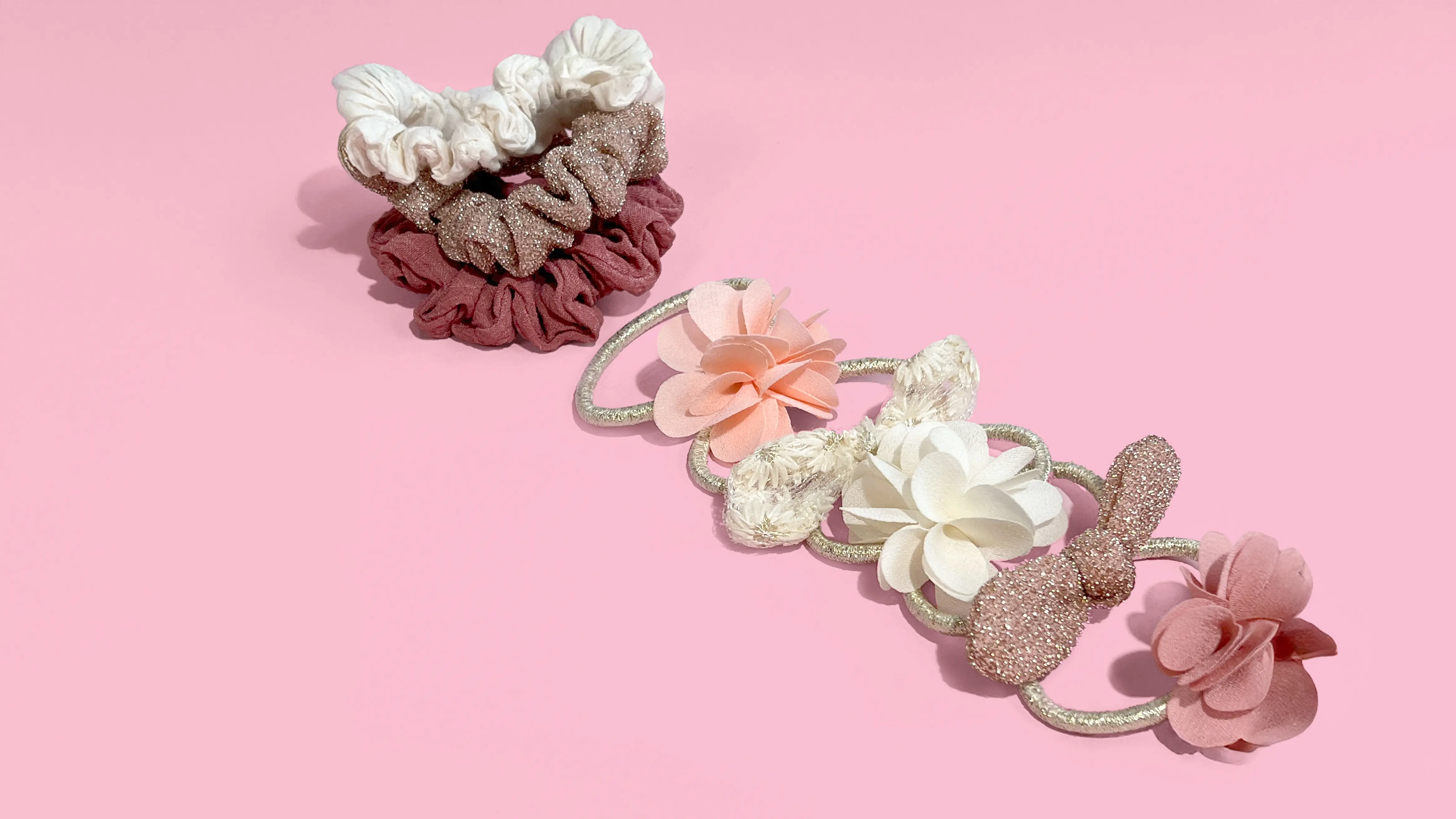 hair accessories with scrunchies & floral hairbands in pink & white, showcasing Kiabi's stylish lineup.