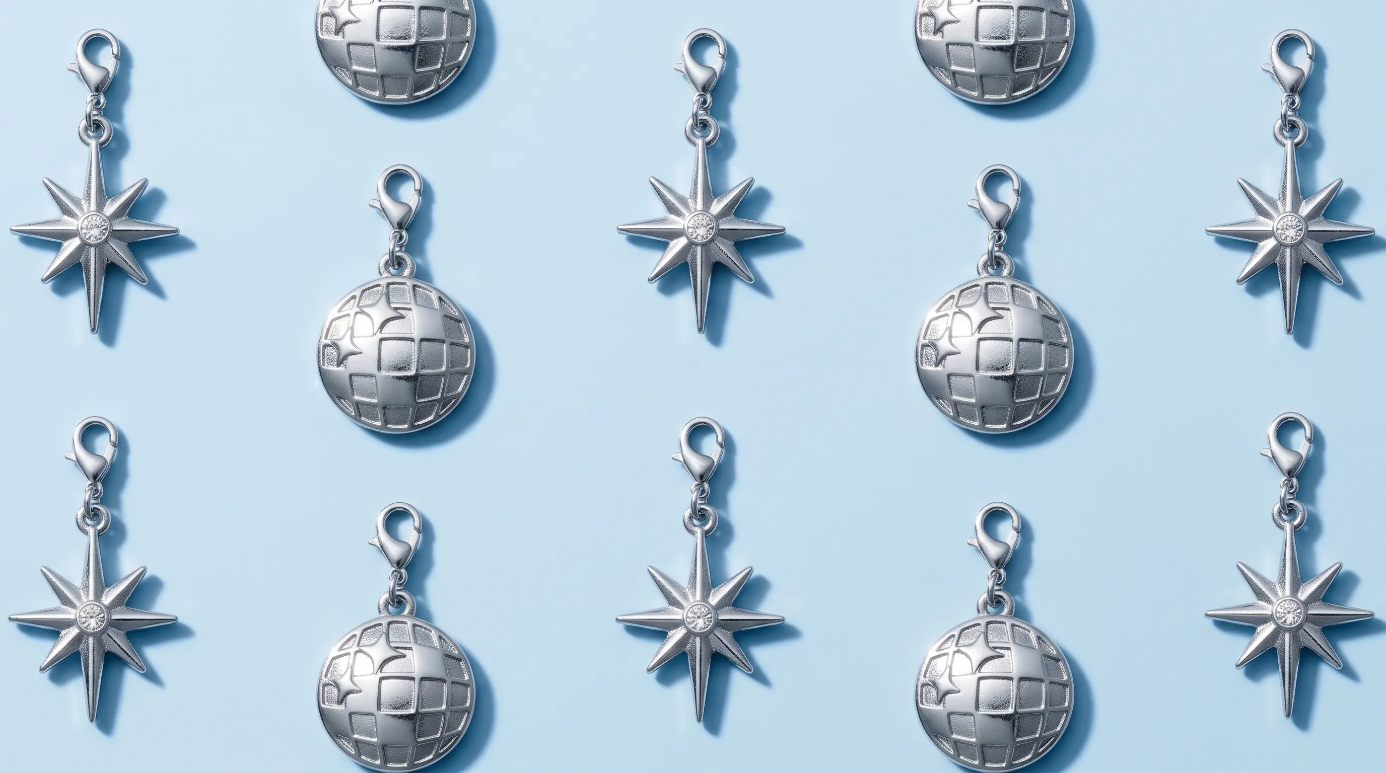 silver globe and star charms with lobster clasps on a light blue background