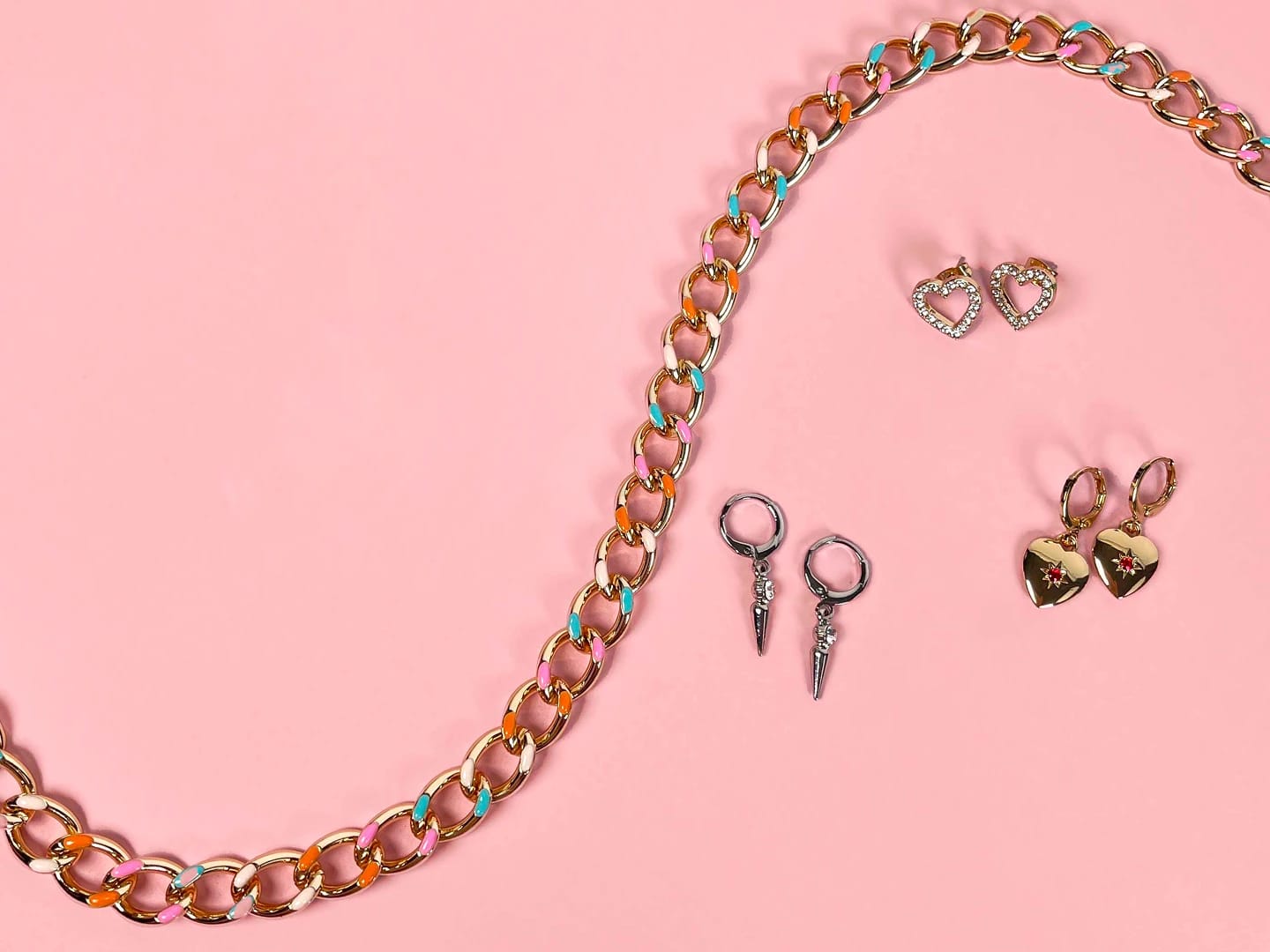 A flat lay of jewelry pieces, including heart-shaped earrings and a statement chain, designed for Oriflame