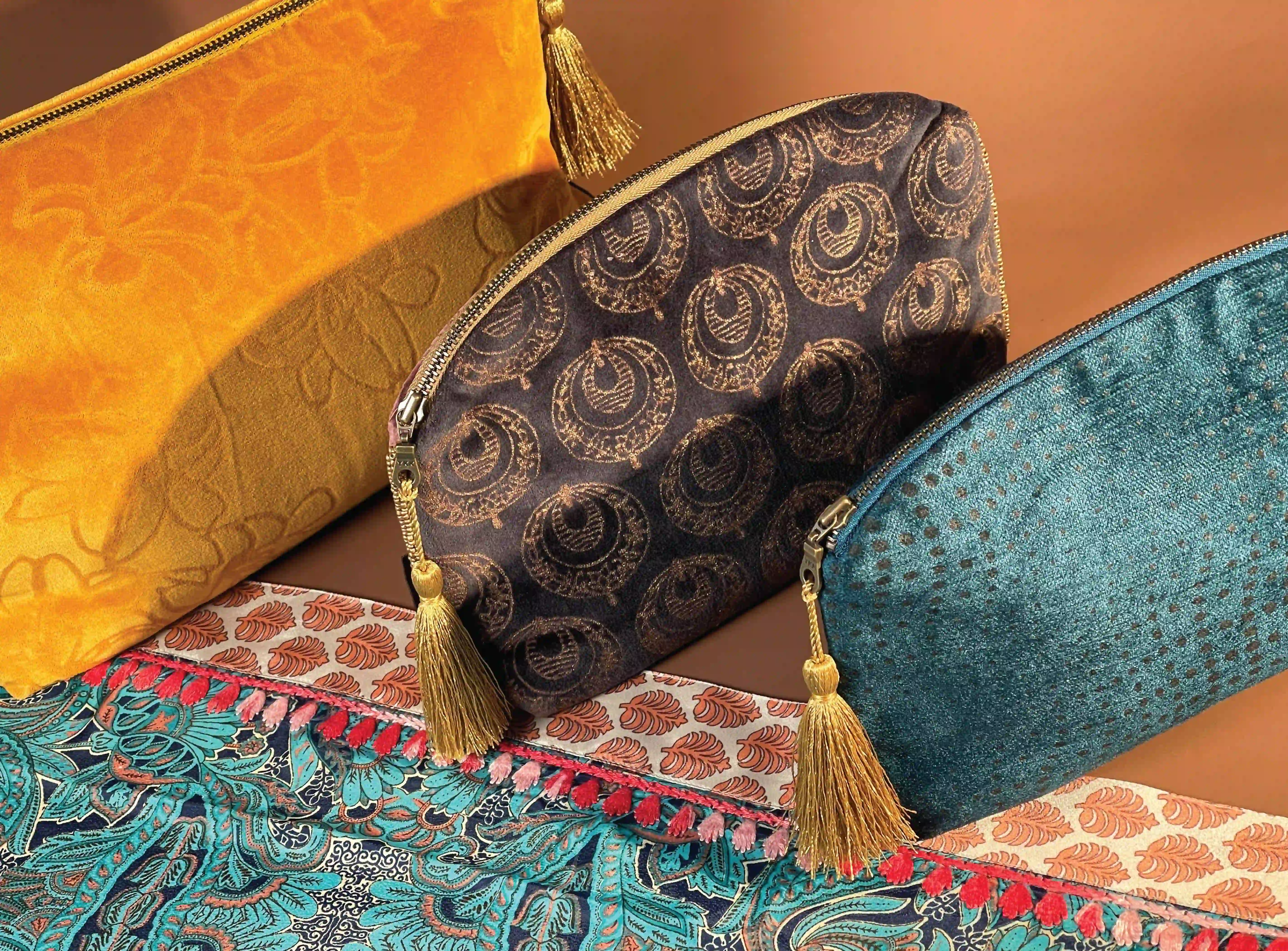 three vibrant pouches—gold, brown with circles & teal—each with tassels, highlighting Rituals' designs.